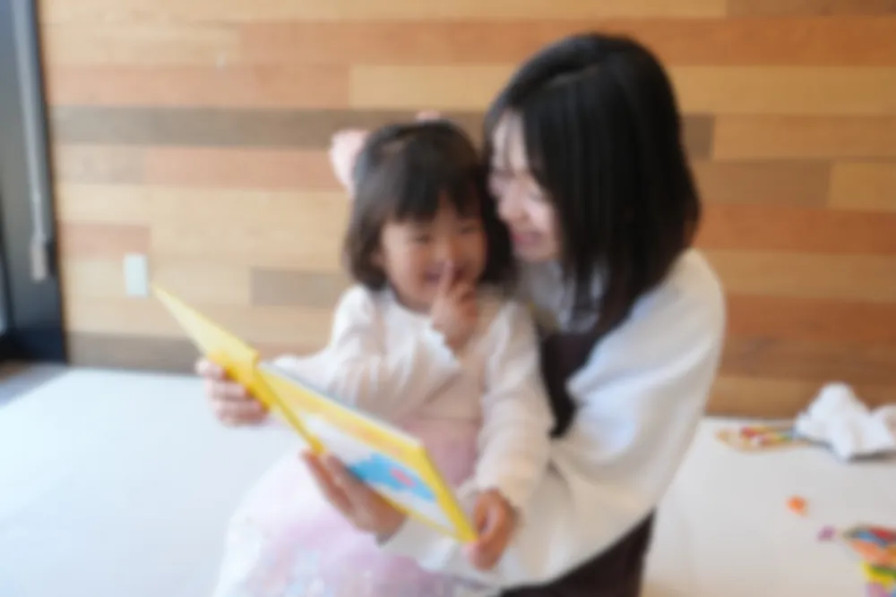ベビーシッターが子どもに絵本を読み聞かせる様子